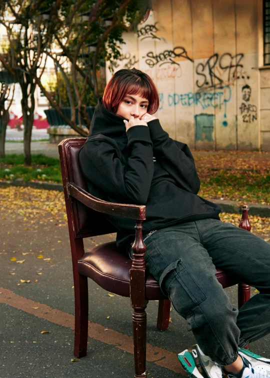 a woman sitting in a chair with her chin up to her face