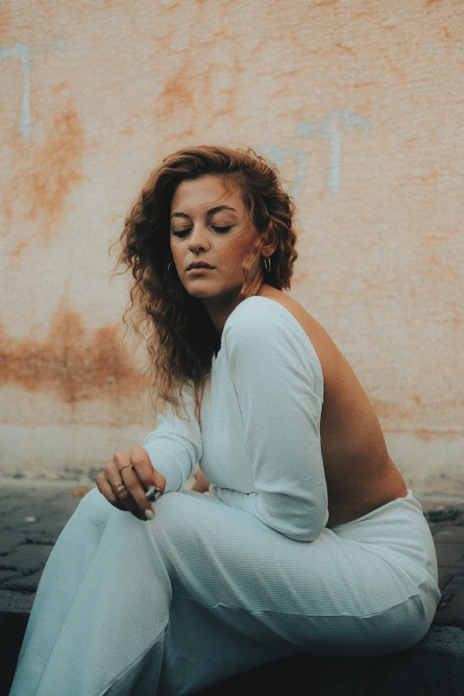 a woman wearing white sitting on the ground