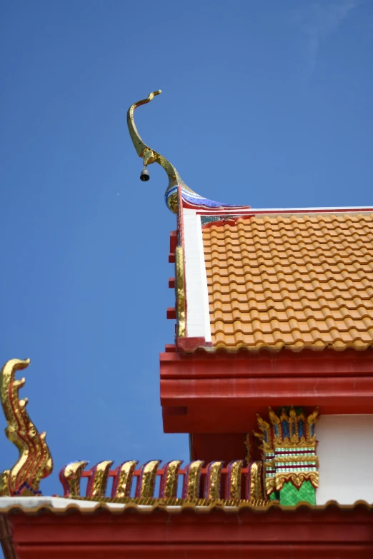 a view up close at a roof of a building with a dragon statue