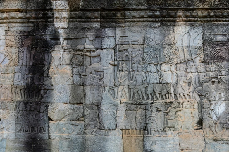 some carvings are on the wall behind an elephant