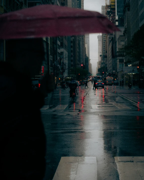 there is people with red umbrellas walking on the street