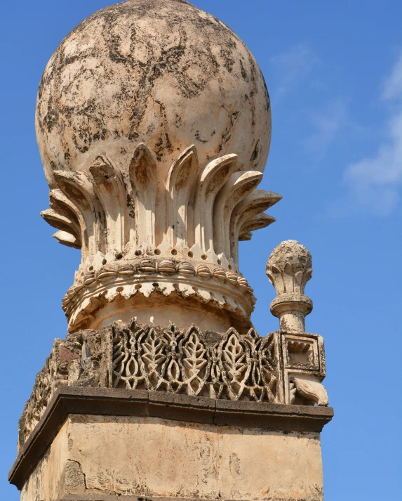 a roof top with stone carving work and a blue sky in the background