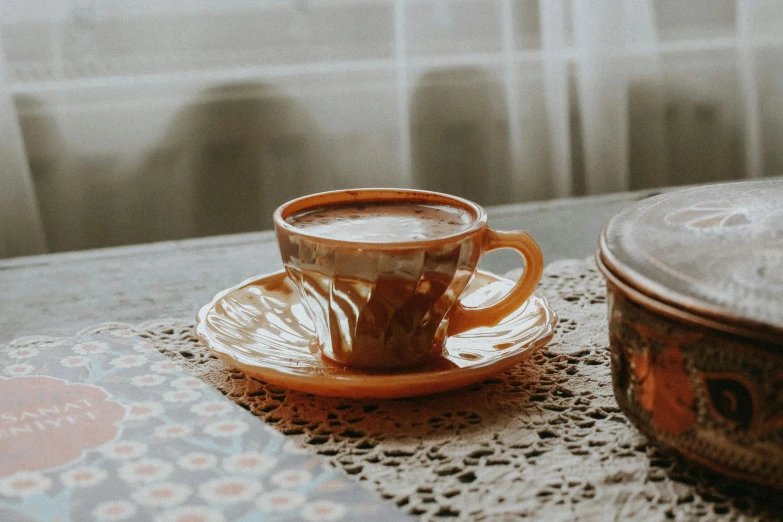 a close up of a plate with a cup of coffee on it