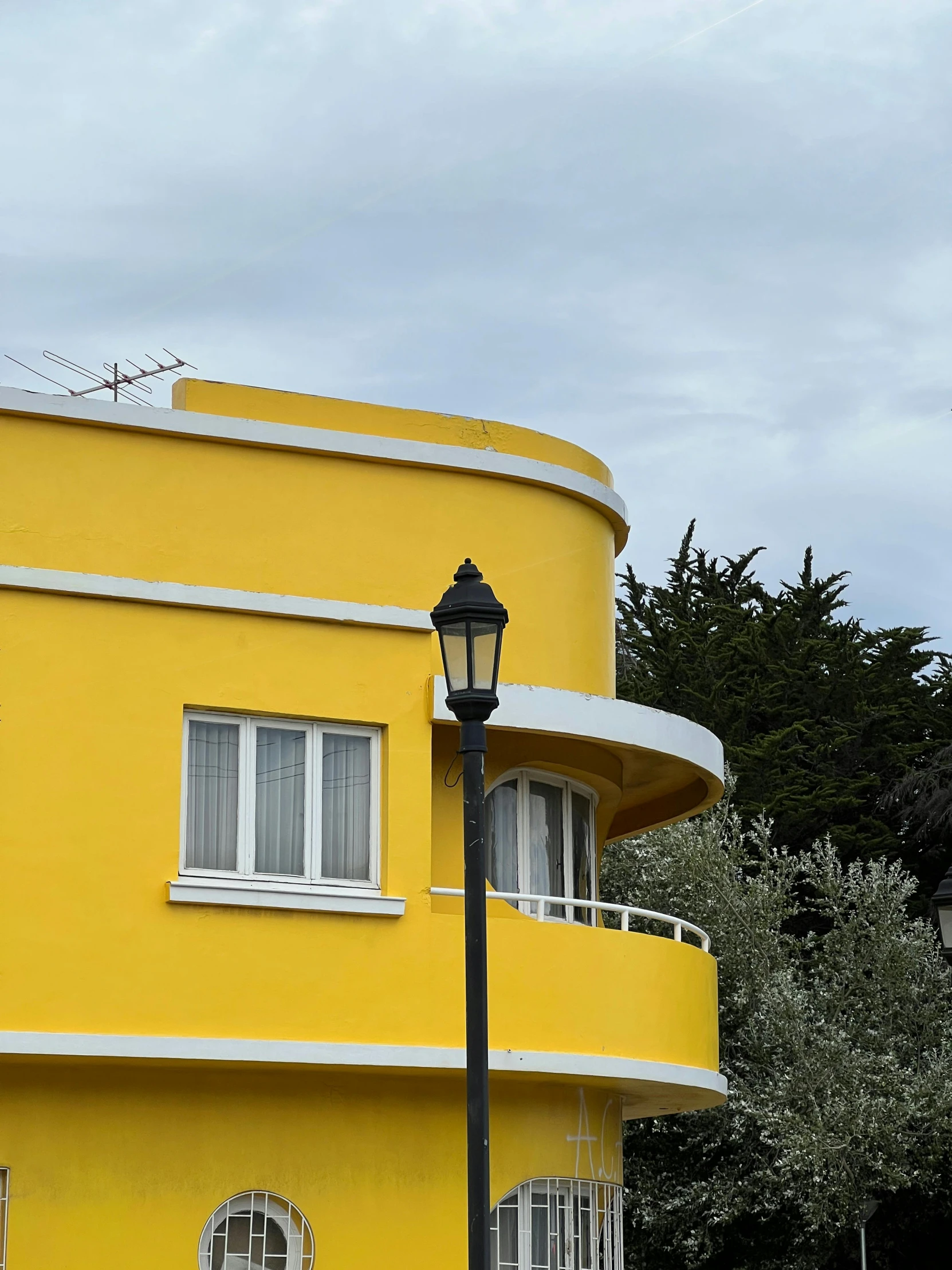 a bright yellow building in front of a lamp post