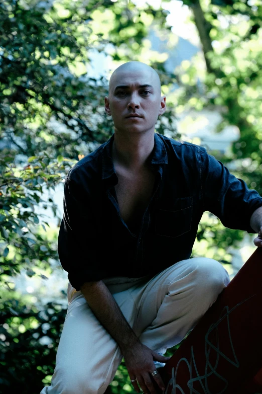 a young man is sitting holding his skateboard