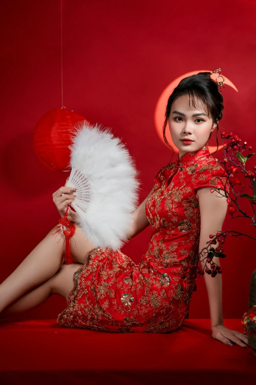 a beautiful woman in red sitting next to a red background