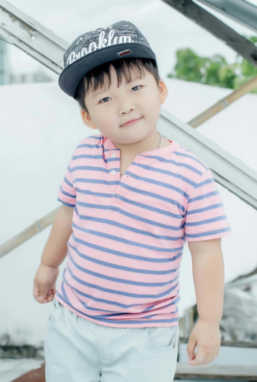 a young child wearing a hat and standing by stairs