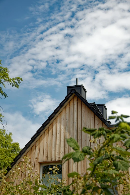 a view of a barn from the side with clouds in the background