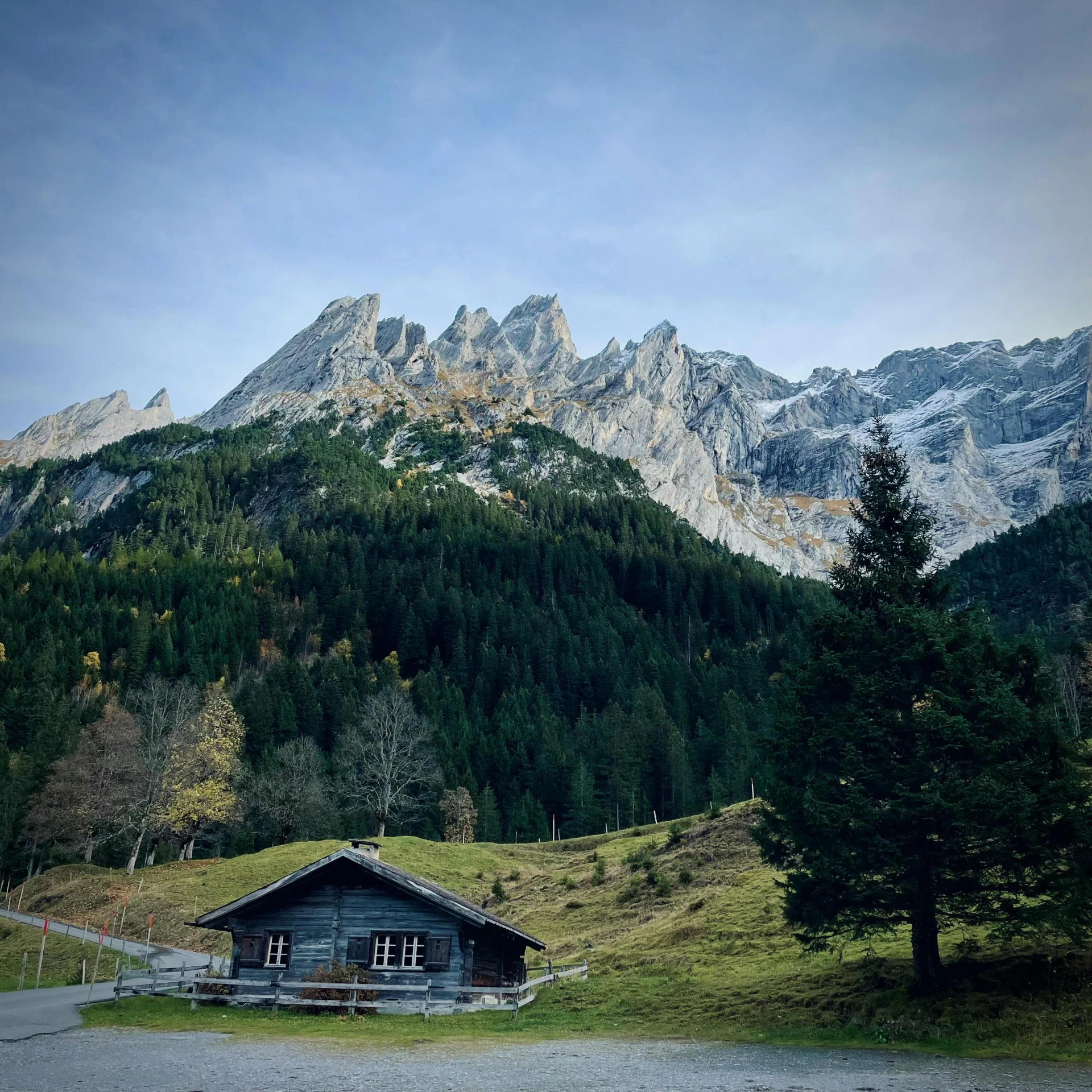 some mountain and road by a house with grass roof