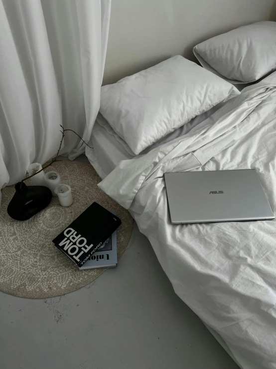 a laptop is sitting on the floor beside a book and lamp