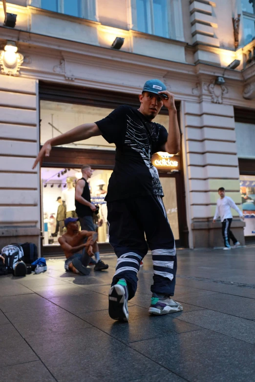 guy dancing in the middle of a plaza in a city