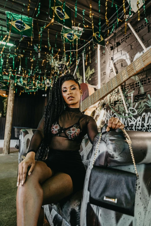 a young lady is sitting against a wall with a guitar hanging from it's ceiling