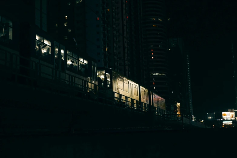 a night scene showing train tracks with large buildings