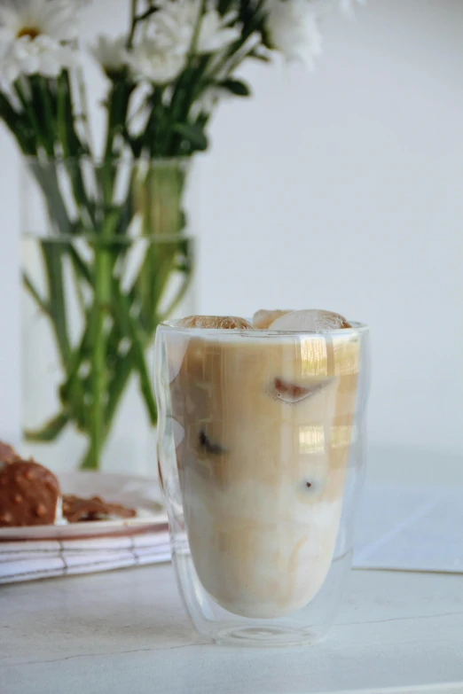 a po of an iced drink and a vase with flowers