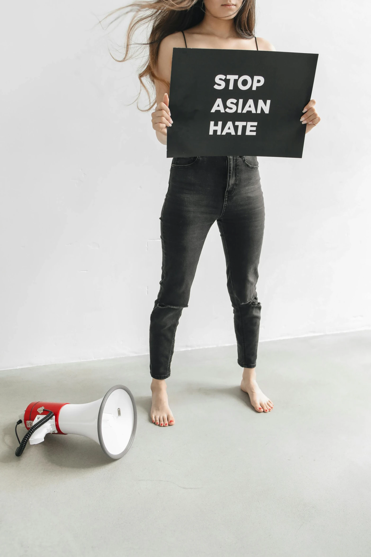 a girl holding up a sign next to a horn