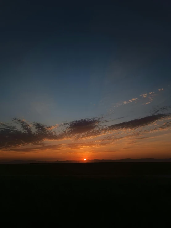 the sun is setting over an open field