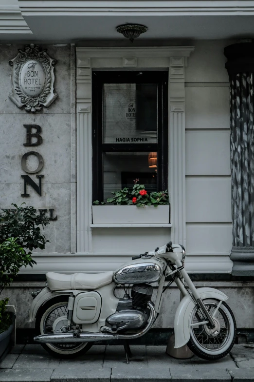 a motorcycle parked on a stone street in front of a bonn