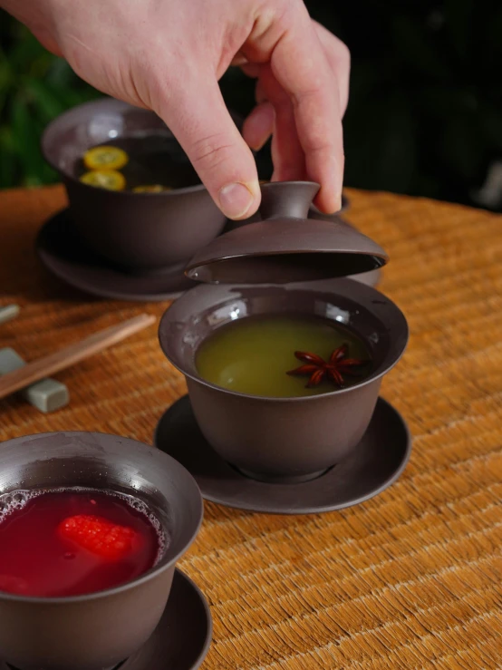 an asian style meal of soup, with chopsticks and saucers on the side