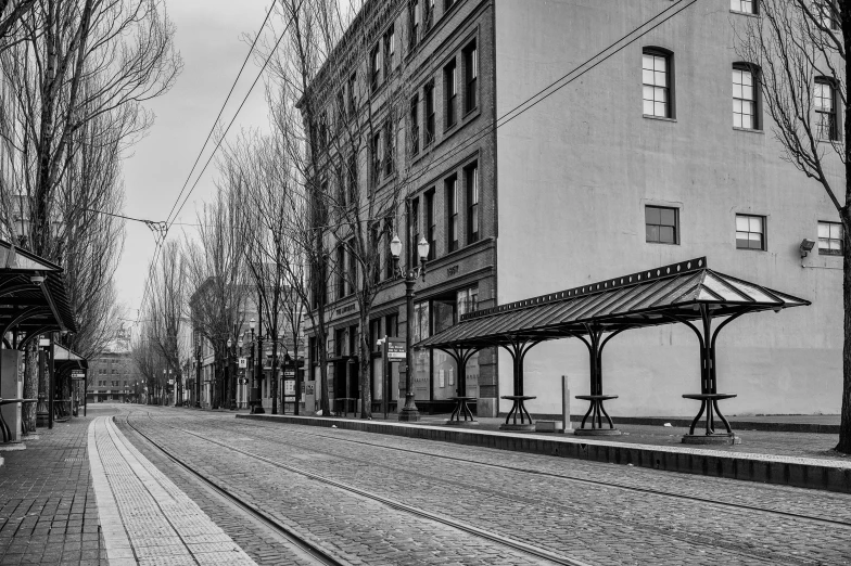 black and white pograph of an empty train track in an old city