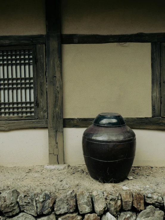 a brown vase in front of an old stone wall