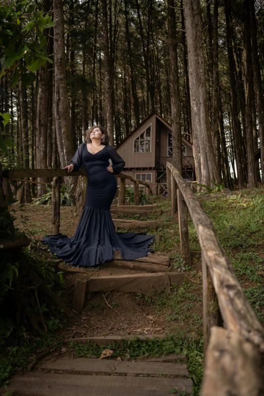 a woman is posing on some steps in front of a house