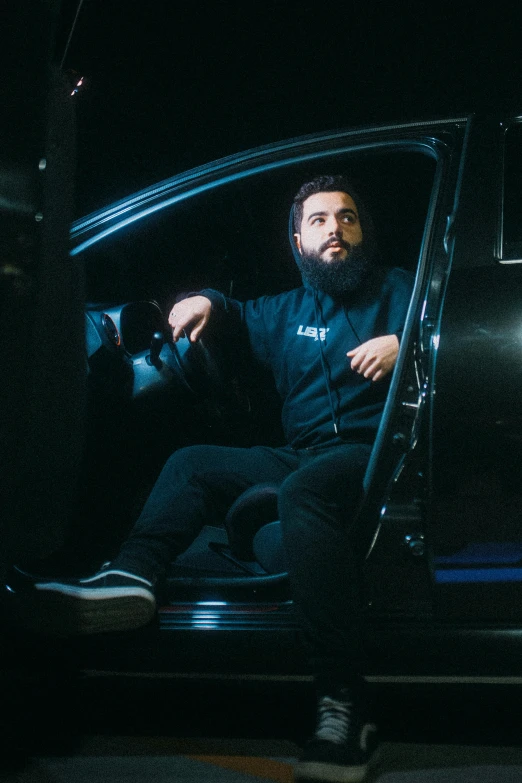 a bearded man sitting in the passenger seat of a car