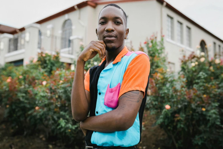 a boy standing in front of a house wearing his arm around his shoulders