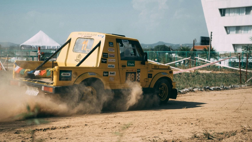 a truck has it's flatbed being hed through a dusty field