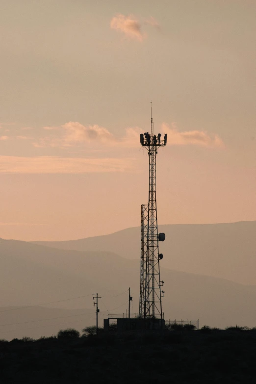 a lone weather station on a hill during sunset