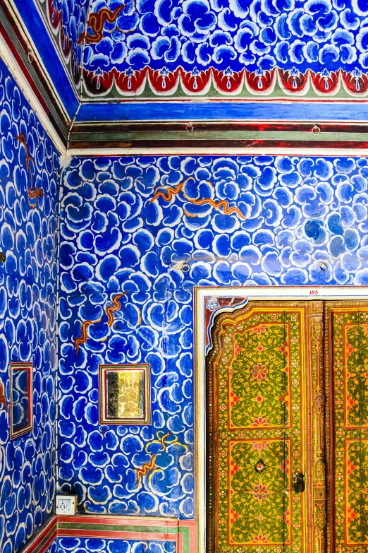 an antique, painted bathroom features a large door and patterned walls