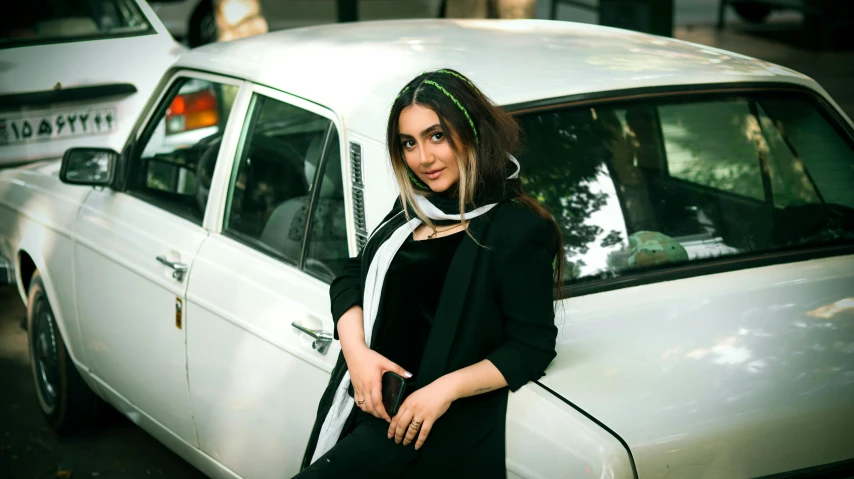 a woman is standing next to a white car