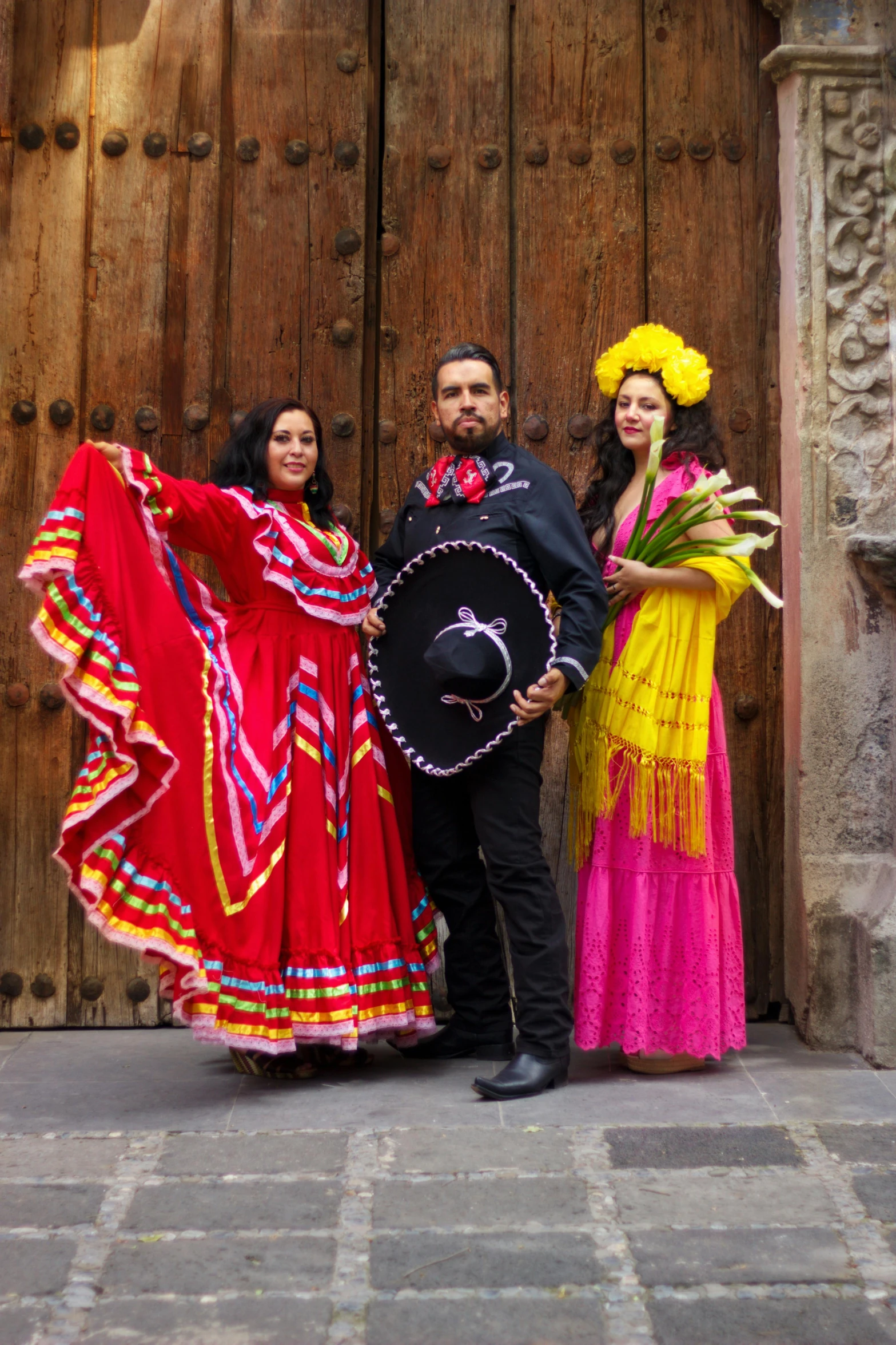 three people posing for a po in front of a wooden door