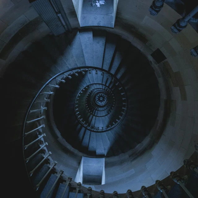 a circular spiral stairway way with a clock and people