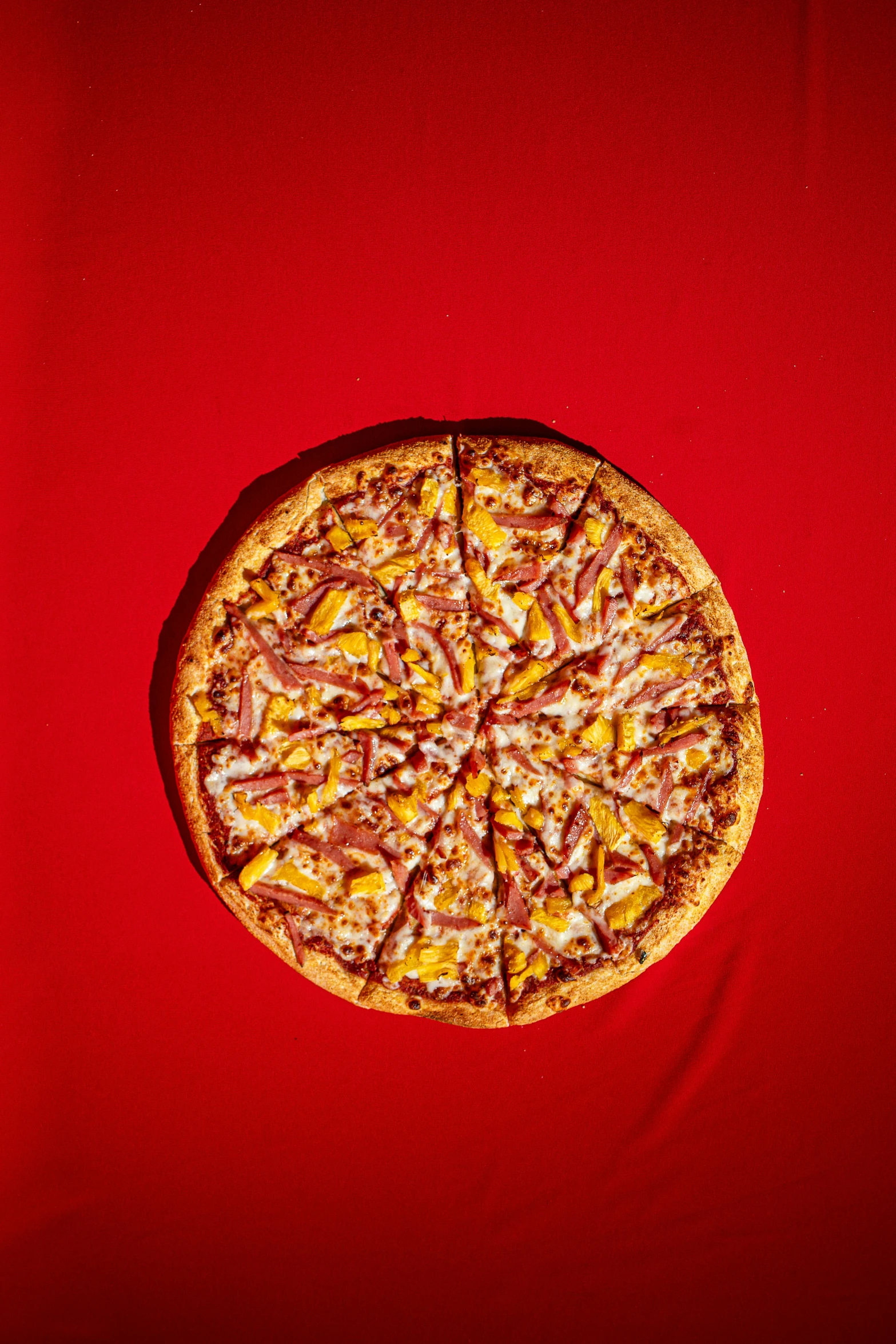 a piece of pizza sits on a red tablecloth