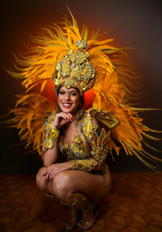 a woman dressed in elaborate golden sequins and feathers