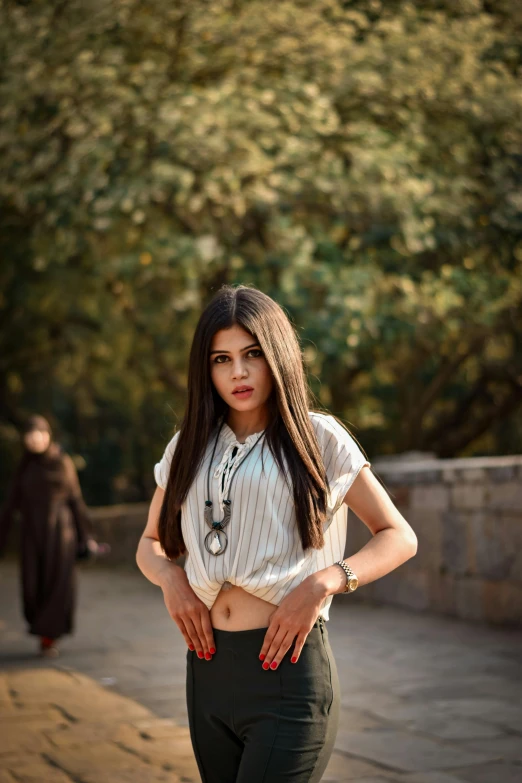 a woman is posing for a picture while wearing dark pants