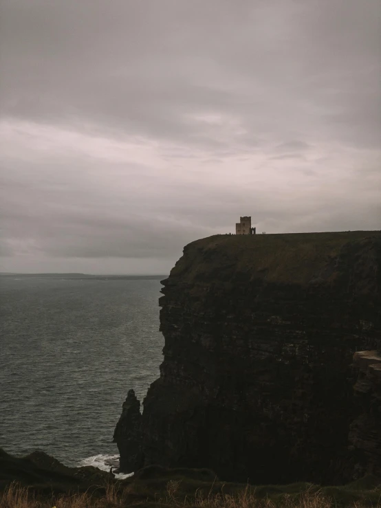 a person standing on a cliff overlooking the ocean