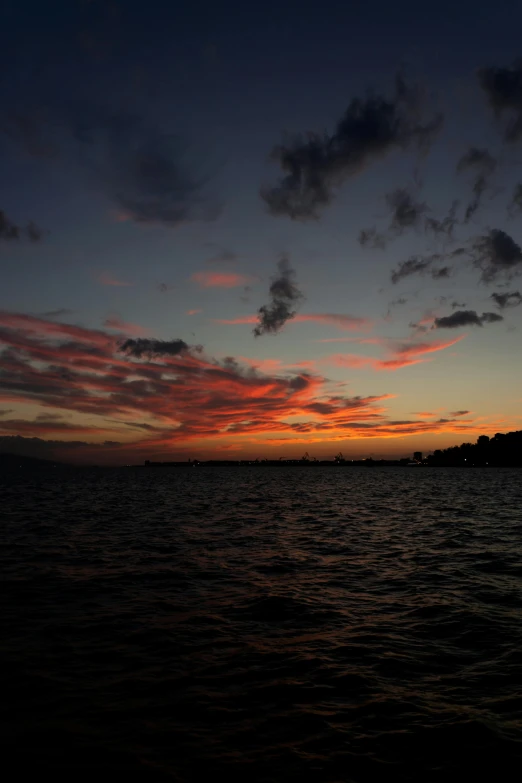 a very colorful sunset over the water in the day time