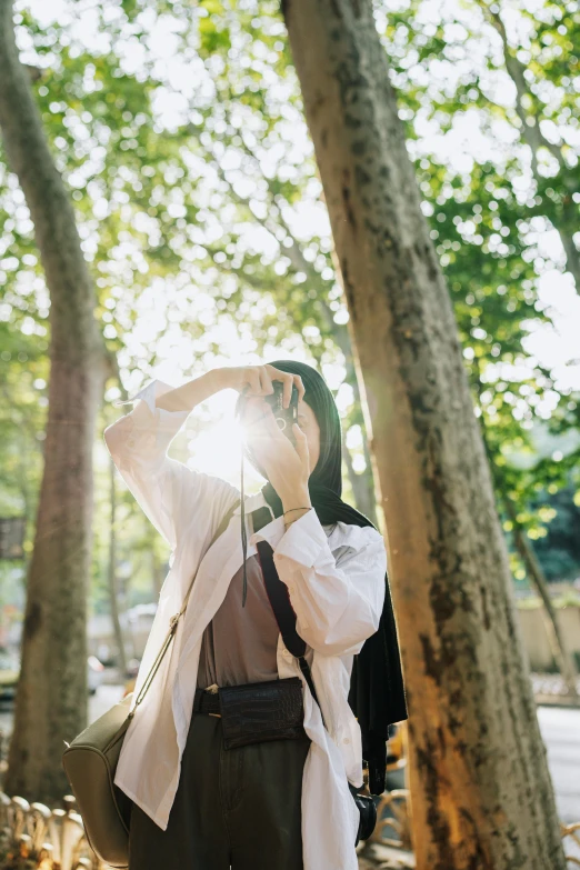 a woman taking a po of some trees