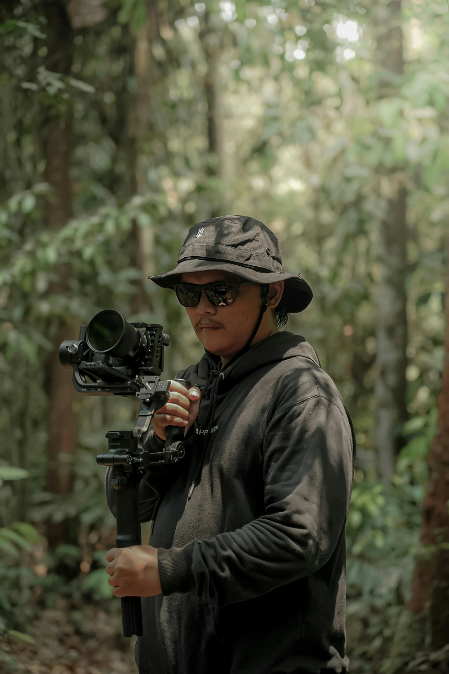 a woman is standing in the woods holding an old fashioned camera