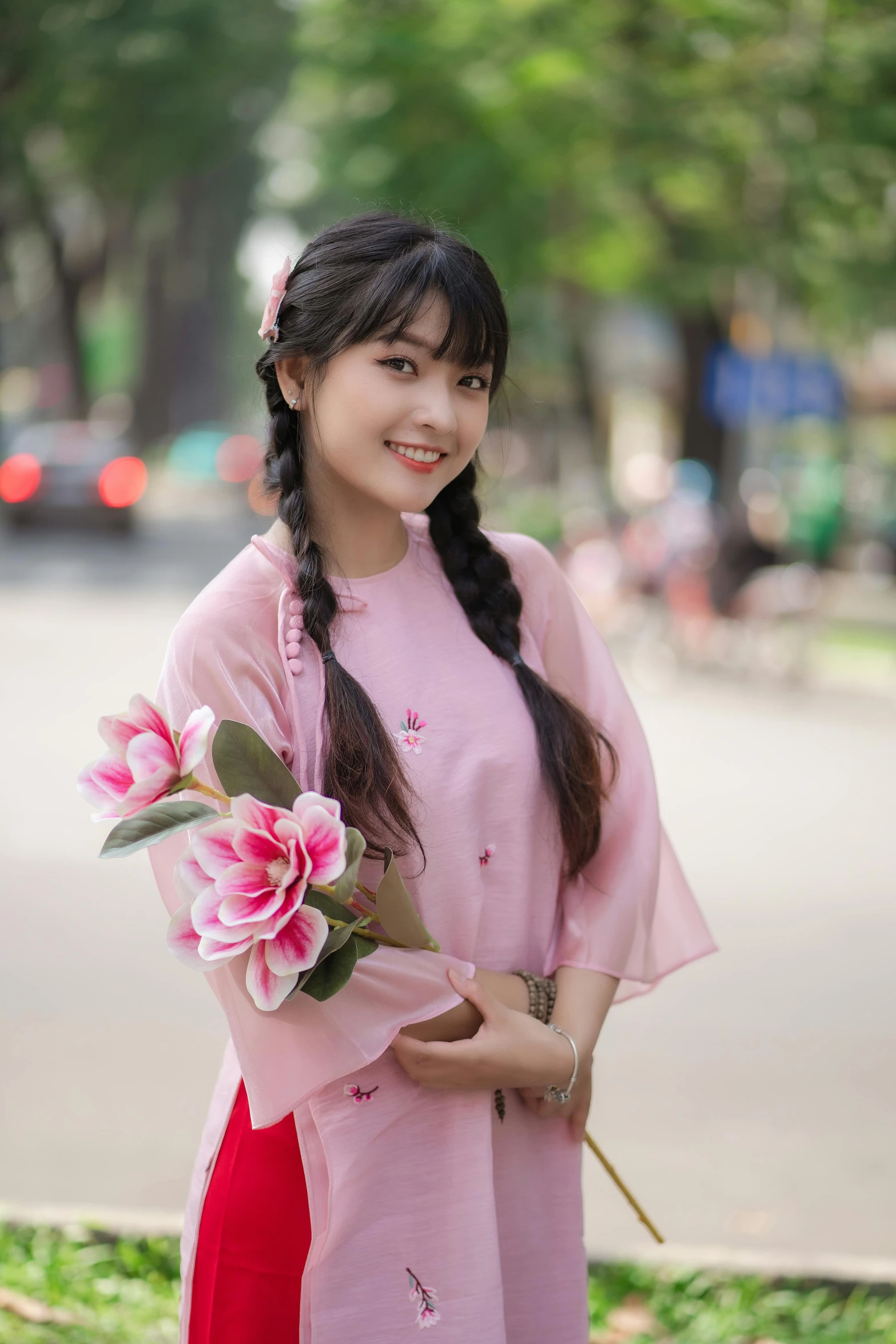 a woman in pink holds up a flower