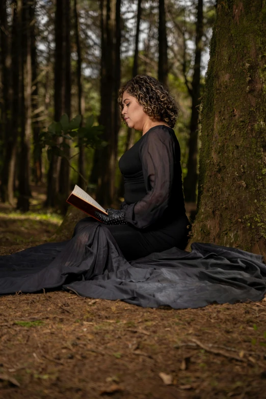 a woman sitting on the ground reading a book