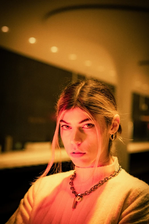 a woman wearing a necklace and a yellow shirt