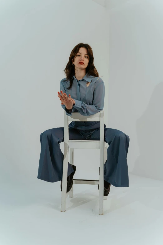 a woman sitting on top of a white chair