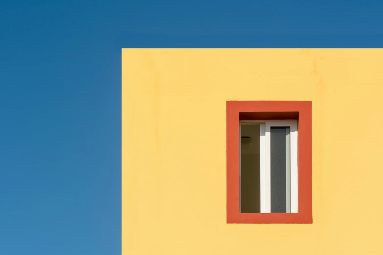 an image of a corner window that appears to be painted yellow