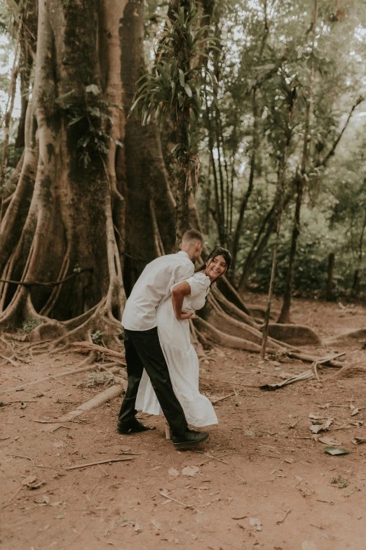 two people in white shirts and black pants are standing around