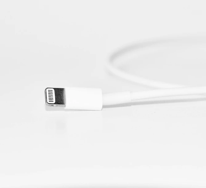 white charger cable with white colored ends on white table