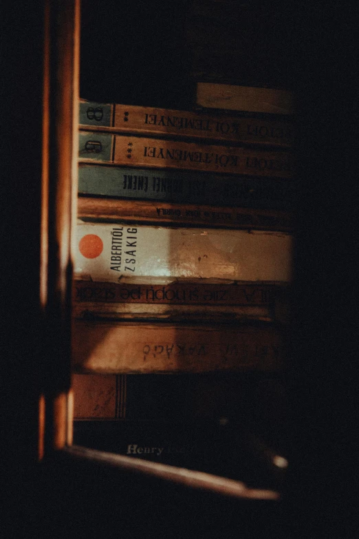 some books sitting on the shelf in the dark