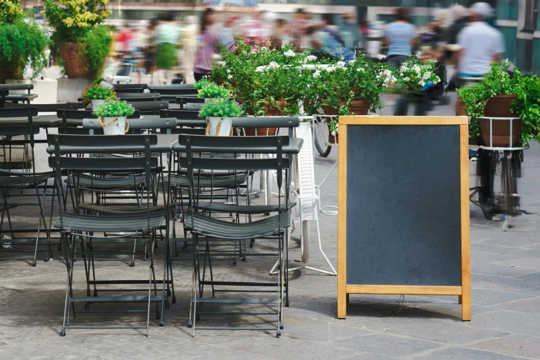 there are a bunch of black tables that are all along the sidewalk