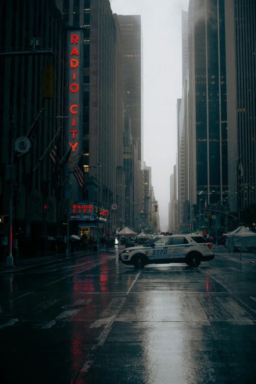 people and vehicles travel through the city during a rainy day